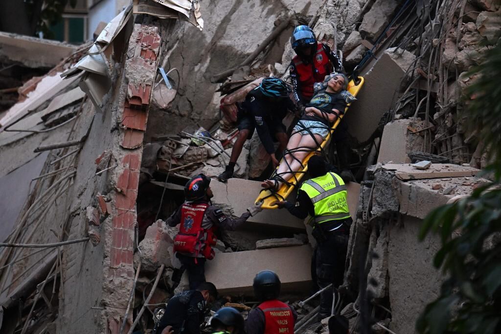 Rescatistas evacuando a una sobreviviente entre los escombros tras el terremoto en Venezuela